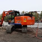 orange elgravemaskin på byggeplass