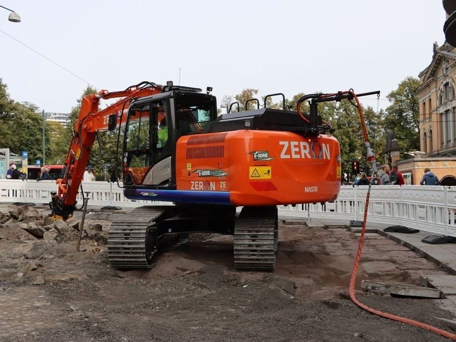 orange elgravemaskin på byggeplass